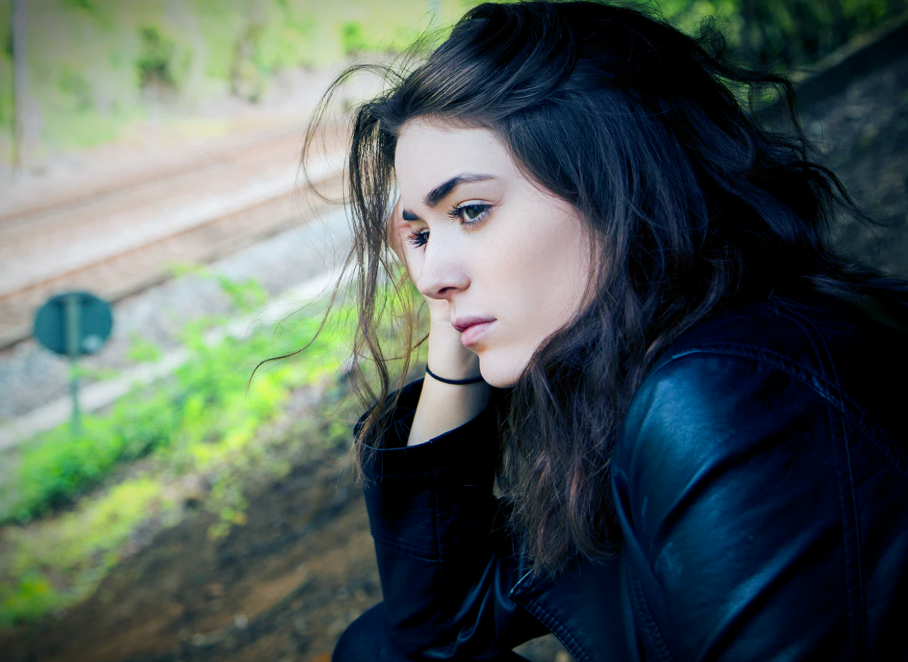 student loans , female leaning on outdoor railing staring down